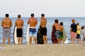 Teenage boys observe the surf and waves waiting to boogie board on the shoreline of Bethany Beach Delaware.