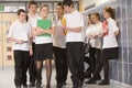 Teenage boys clustered around a girl at school