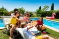 Teenage boys and girls drink cold soda, pool party