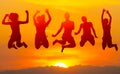 Teenage boys and girls jumping high in the air against sunset Royalty Free Stock Photo