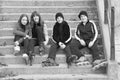 Teenage boys and girls in roller skates sitting on stairs Royalty Free Stock Photo