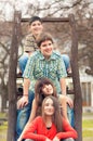 Teenage boys and girls sitting in park on beautiful spring day Royalty Free Stock Photo