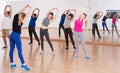 Teenage boys and girls with trainer stretching in dance hall