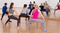 Teenage boys and girls with trainer stretching in dance hall Royalty Free Stock Photo