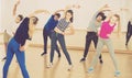 Teenage boys and girls with trainer stretching in dance hall Royalty Free Stock Photo