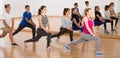 Teenage boys and girls with trainer stretching in dance hall Royalty Free Stock Photo