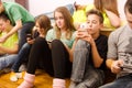 Teenage boys and girls using mobile phones while sitting at home