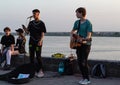 teenage boys play and sing in street on river background. Boy electric guitar playing for people Royalty Free Stock Photo