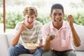 Teenage Boys Sitting On Couch Eating crisps