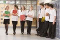 Teenage boys watching girls walk down corridor Royalty Free Stock Photo