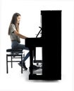 Teenage brunette girl and black upright piano in studio Royalty Free Stock Photo