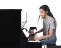 Teenage brunette girl and black upright piano in studio Royalty Free Stock Photo