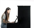 Teenage brunette girl and black upright piano in studio Royalty Free Stock Photo