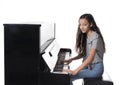 Teenage brunette girl and black upright piano in studio Royalty Free Stock Photo