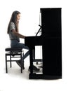 Teenage brunette girl and black upright piano in studio