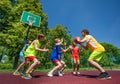 Teenage children playing basketball game together Royalty Free Stock Photo