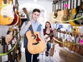 Teenage choosing best acoustic guitar