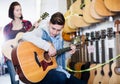 Teenage choosing best acoustic guitar