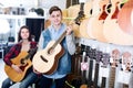 Teenage choosing best acoustic guitar