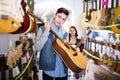 Teenage choosing best acoustic guitar