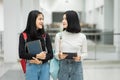 Teenage college friend students walking and chatting in college campus while having break after class. Two happy students walking Royalty Free Stock Photo