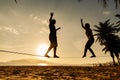 Teenage couple balancing slackline on the beach