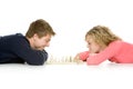 Teenage couple lying down playing chess Royalty Free Stock Photo