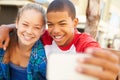 Teenage Couple Sitting On Bench In Mall Taking Selfie Royalty Free Stock Photo