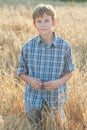 Teenage farmer standing among field of barley