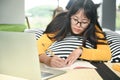 Teenage female student sleep on pillows read book and use laptop.She writes notes to prepare for the exam Royalty Free Stock Photo