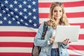 Teenage female students fills in visa application online with a flag of USA in the background