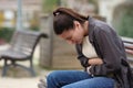 Teenage female suffering belly ache in a park Royalty Free Stock Photo