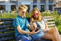 Teenage friends girl and boy sitting on bench in city, talking. Friendship and people concept Royalty Free Stock Photo