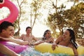 Teenage friends have fun with inflatables in a swimming pool Royalty Free Stock Photo