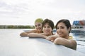 Teenage Friends Resting At The Edge Of Swimming Pool Royalty Free Stock Photo