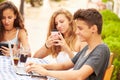 Teenage Friends Sitting At CafÃ¯Â¿Â½ Using Digital Devices Royalty Free Stock Photo