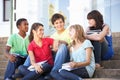 Teenage Friends Sitting On College Steps Outside