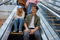 Teenage friends team moving staircase at shopping mall