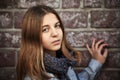 Sad fashion teen girl against a brick wall Royalty Free Stock Photo