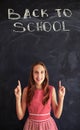 Teenage girl against chalk inscription on blackboard showing for