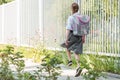 Girl with a backpack goes along the sidewalk to school on a sunny day