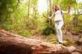 Teenage girl balancing on a fallen tree in a forest