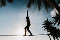 Teenage girl balancing on slackline with sky view