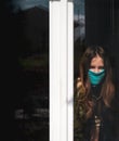 Teenage Girl Behind Window Wearing Home Made Face Mask. Stay At Home Lonely