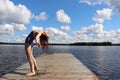 Girl bending backwards on a pier at a lake in Finland Royalty Free Stock Photo