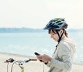 Teenage girl with bike listening to music on her phone. Royalty Free Stock Photo