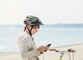 Teenage girl with bike listening to music on her phone. Royalty Free Stock Photo