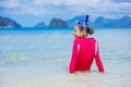 Teenage girl in bikini carrying scubadiving equipment