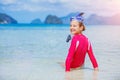 Teenage girl in bikini carrying scubadiving equipment