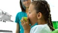 Teenage girl biting apple in stomatology office, dentist smiling at background Royalty Free Stock Photo